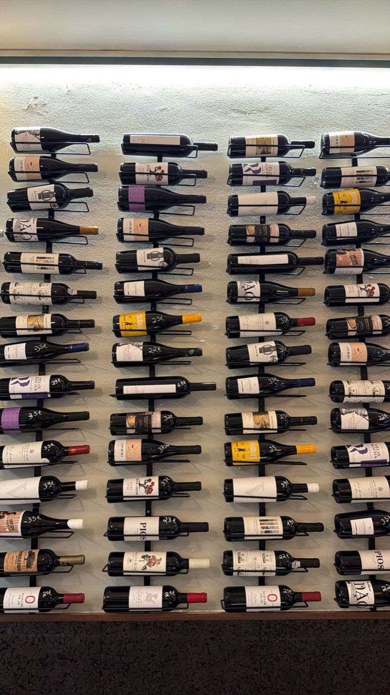 Parede de garrafas de vinho expostas no Noémia